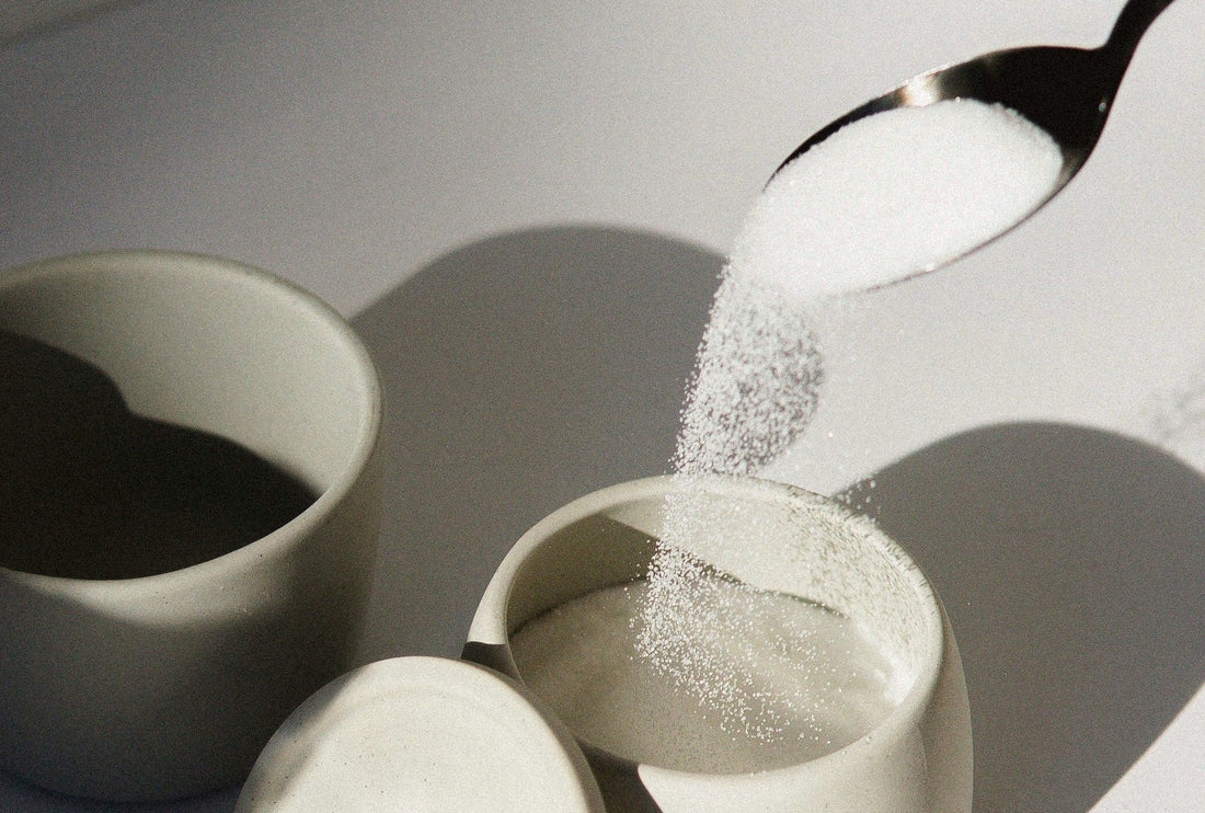 Teaspoon pouring sugar into cup
